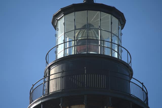 The lantern room of Yaquina Head Lighthouse against a deep blue sky