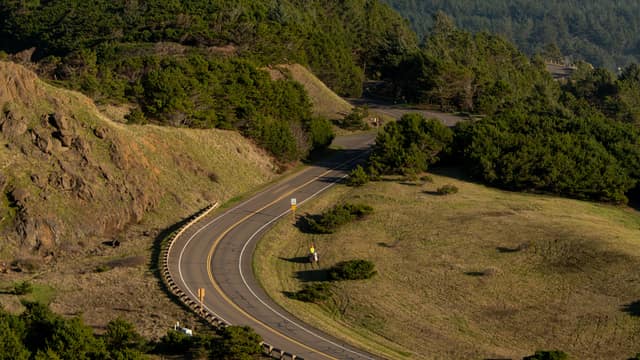 Coastal road winding through green bluffs