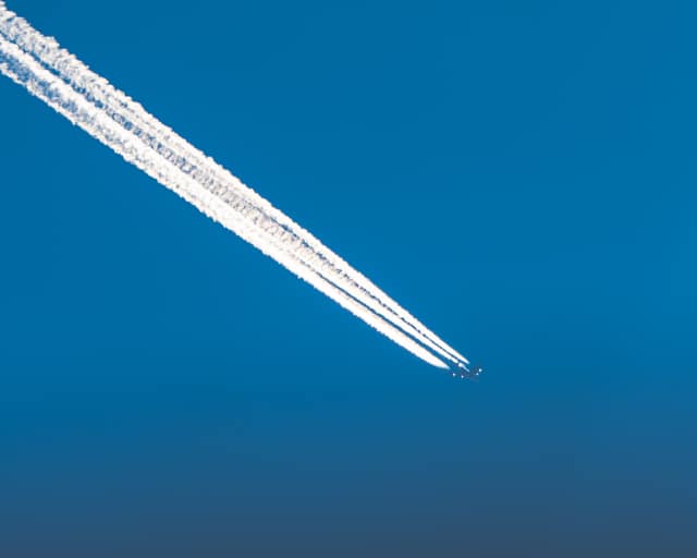 Contrail slicing a clear sky