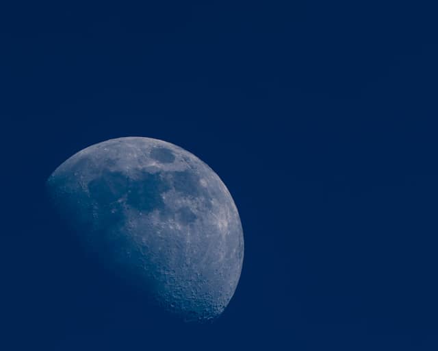Moon rising through deep blue