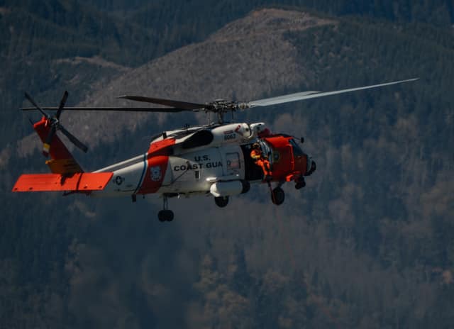 Coast Guard helicopter over the hills