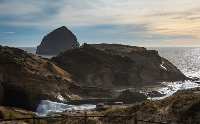 Waves breaking around a coastal monolith