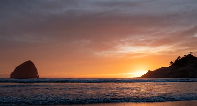 Burning sky behind coastal rocks