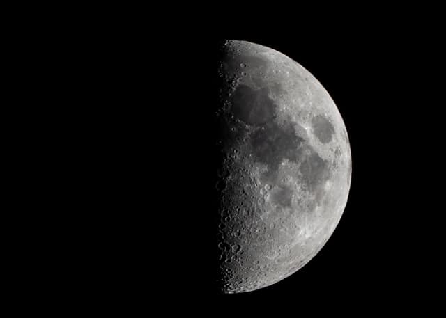 Waxing moon against black sky