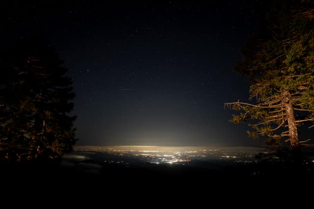 City lights spread below a mountain at dusk