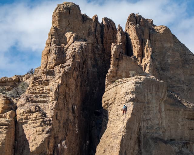 Climbers scaling towering rock spires under a clear sky