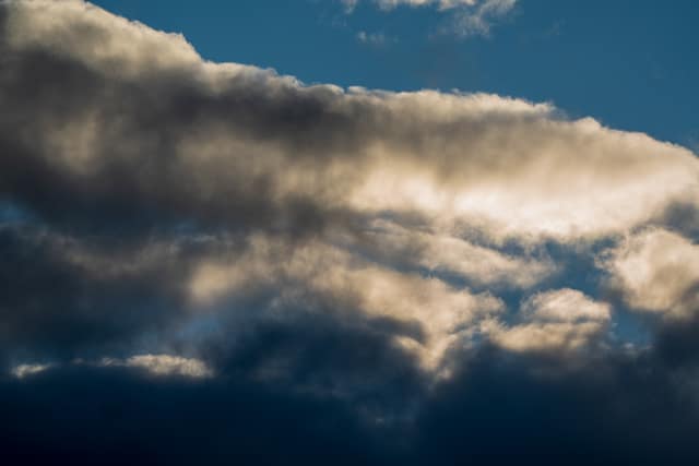 Storm clouds stacked over dark hills