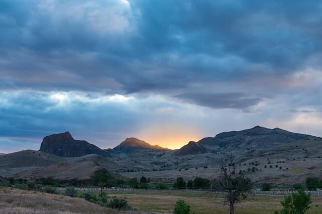 Sunset flaring behind a desert butte