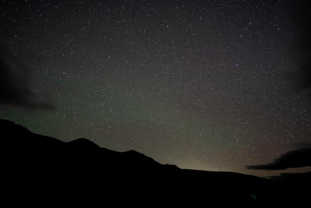 Night sky over a dark ridge
