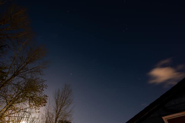 Moonlit clouds over a dark rooftop
