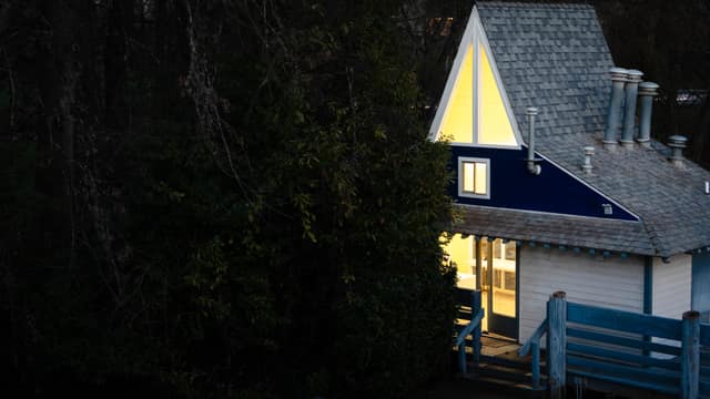 A house with warmly lit windows against the blue of dusk